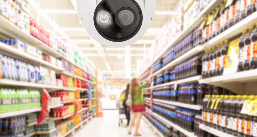 Modern security camera and shoppers at grocery store